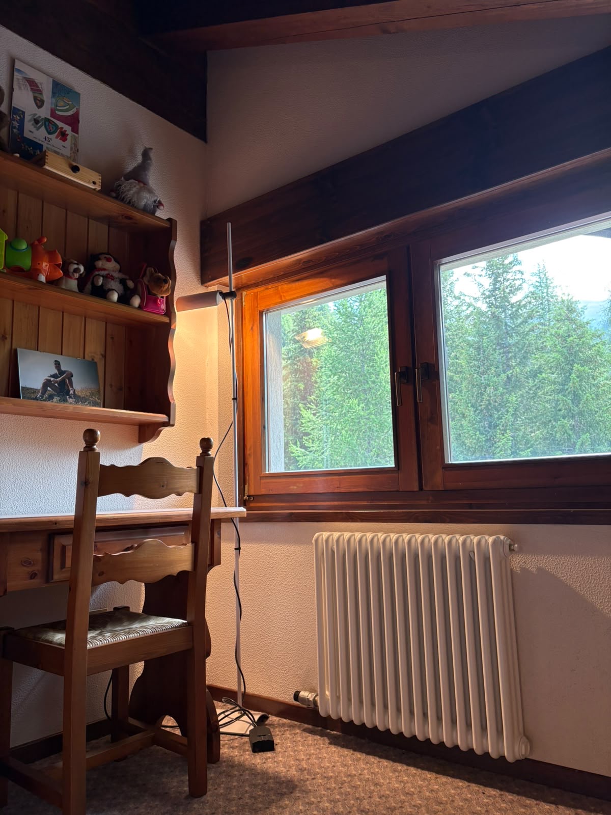 Romantica camera mansardata con travi in legno a vista in stile chalet
